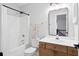 Bright bathroom featuring white fixtures, a wood vanity, and a bathtub with a shower in a well-lit space at 2050 S Smokerise Way, Mount Pleasant, SC 29466