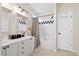 Bright bathroom featuring a dual sink vanity, framed mirrors, and a shower-tub combo with decorative tile accents at 2050 S Smokerise Way, Mount Pleasant, SC 29466