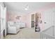 Charming bedroom with pink walls, soft carpet, a white crib, and a sitting area bathed in natural light at 2050 S Smokerise Way, Mount Pleasant, SC 29466