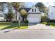 Inviting two-story home with a manicured lawn and a two-car garage, set against a backdrop of mature trees at 2050 S Smokerise Way, Mount Pleasant, SC 29466