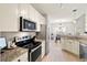 Modern kitchen with stainless steel appliances, granite countertops, and white cabinets, adjoining a dining area at 2050 S Smokerise Way, Mount Pleasant, SC 29466