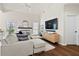 Open-concept living room with a large sofa, wood floors, and a fireplace, offering a cozy and modern space at 2050 S Smokerise Way, Mount Pleasant, SC 29466