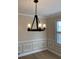 Close-up of a dining room featuring a modern chandelier, crown molding, and classic wainscoting at 208 Woodland Dr, Summerville, SC 29485