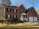 Charming two-story brick home with a two-car garage and manicured lawn on a sunny day at 208 Woodland Dr, Summerville, SC 29485