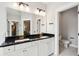 Bathroom with double vanity, white cabinets, black countertop, gold hardware, and large mirror at 2165 Annie Laura Ln, Mount Pleasant, SC 29466