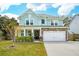 Charming two-story home with a light blue exterior, stone accents, manicured lawn and a two-car garage at 2165 Annie Laura Ln, Mount Pleasant, SC 29466