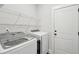 Efficient laundry room with modern washer and dryer, wire shelving, and access door at 2165 Annie Laura Ln, Mount Pleasant, SC 29466