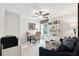 Bright office space features a ceiling fan, desk, shelving, and comfortable seating area with a navy sofa and floral pillows at 2165 Annie Laura Ln, Mount Pleasant, SC 29466