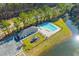 Aerial shot of a community pool with lounge chairs, a playground, and adjacent to a lake and treeline at 223 Sugarberry Lane, Moncks Corner, SC 29461