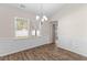 Bright dining area featuring hardwood floors, wainscoting, large windows, and a modern chandelier at 223 Sugarberry Lane, Moncks Corner, SC 29461