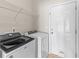 Well-lit laundry room featuring modern washer, dryer, and convenient shelving for storage at 223 Sugarberry Lane, Moncks Corner, SC 29461