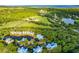 Beautiful aerial view of property featuring a lake, horse pasture, landscaping, and blue skies at 2472 Racquet Club Dr, Seabrook Island, SC 29455