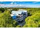 Aerial view of the condo building featuring multiple balconies, a blue metal roof, and lush surrounding trees at 2472 Racquet Club Dr, Seabrook Island, SC 29455
