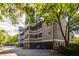 Condo building with multiple balconies and parking underneath, surrounded by lush greenery and blue sky at 2472 Racquet Club Dr, Seabrook Island, SC 29455