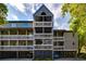 Multi-story condo building featuring balconies and covered parking, under a blue sky with scattered clouds at 2472 Racquet Club Dr, Seabrook Island, SC 29455
