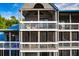 Multi-story condo building with screened in balconies, white railings, and light gray siding at 2472 Racquet Club Dr, Seabrook Island, SC 29455