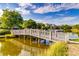Exterior view of a wooden bridge and the lake, surrounded by greenery and beautiful houses in the distance at 2472 Racquet Club Dr, Seabrook Island, SC 29455