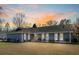 Charming single-story home featuring a well-manicured lawn and lush landscaping at sunset at 2899 Doncaster Dr, Charleston, SC 29414