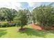 Well-maintained backyard with lush green grass, trees, and partial view of a pond at 2920 Woodland Park Dr, Mount Pleasant, SC 29466