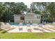 Relaxing pool scene with outdoor seating, building, and greenery under a sunny sky at 2920 Woodland Park Dr, Mount Pleasant, SC 29466