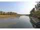 Scenic view of a serene river with a wooden pier and lush marshland along the banks at 2961 Yachtsman Dr, Mount Pleasant, SC 29466