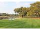 Scenic backyard featuring three chairs on the lawn, mature trees and a serene view of the river at 2961 Yachtsman Dr, Mount Pleasant, SC 29466