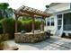 An outdoor kitchen features stone counters, a grill, seating and a wooden pergola with a marlin decoration at 2961 Yachtsman Dr, Mount Pleasant, SC 29466