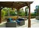 Inviting outdoor patio with comfortable seating, a pergola with a ceiling fan, and a stone firepit at 2961 Yachtsman Dr, Mount Pleasant, SC 29466