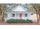 Charming cottage-style house with a porch, coral front door, and white exterior at 3166 Edenvale Rd, Johns Island, SC 29455
