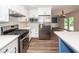 Kitchen featuring stainless steel appliances, white cabinets, stone countertops, subway tile backsplash, and wood-look flooring at 3166 Edenvale Rd, Johns Island, SC 29455