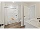 All-white bathroom with modern fixtures, wood-look flooring, and a shower with a bathtub at 3215 Safe Harbor Way, Charleston, SC 29414
