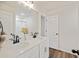 Bright bathroom featuring double sinks, wood-look flooring, and a large mirror at 3215 Safe Harbor Way, Charleston, SC 29414