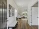 Bright entryway with wood floors, a white bench, and a view into the living room with abundant natural light at 3215 Safe Harbor Way, Charleston, SC 29414