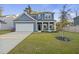Charming two-story home with a well-manicured lawn, attached garage, and classic architectural details at 3215 Safe Harbor Way, Charleston, SC 29414