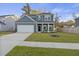 Charming two-story home with a well-manicured lawn, inviting curb appeal, and a wide driveway leading to a two-car garage at 3215 Safe Harbor Way, Charleston, SC 29414