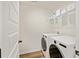 Well-lit laundry room with modern white washer and dryer and wire shelving at 3215 Safe Harbor Way, Charleston, SC 29414