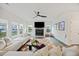 Spacious living room with a modern ceiling fan, fireplace, large windows, and a comfortable white sectional at 3215 Safe Harbor Way, Charleston, SC 29414