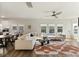 Open-concept living area with a large white sectional, wood floors, modern fan, and plentiful natural light at 3215 Safe Harbor Way, Charleston, SC 29414