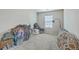 Empty bedroom offers potential with neutral carpet and a bright window, staged with bags at 343 Iveson Rd, Summerville, SC 29486