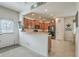 Open kitchen with cherry cabinets and an eat-in bar, adjacent to the dining area and living room at 343 Iveson Rd, Summerville, SC 29486