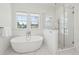 Bright bathroom featuring a soaking tub, a glass-enclosed shower, and a large window at 3894 Sawyers Island Dr, Mount Pleasant, SC 29466
