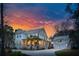 Charming two-story home with inviting front porch and a separate garage, all set against a beautiful sunset at 3894 Sawyers Island Dr, Mount Pleasant, SC 29466
