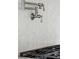 Close-up of a pot filler and stovetop with decorative white backsplash tiles in a modern kitchen at 3894 Sawyers Island Dr, Mount Pleasant, SC 29466
