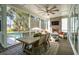 Comfortable screened-in porch with dining table, ceiling fan, brick fireplace, television, and seating at 3894 Sawyers Island Dr, Mount Pleasant, SC 29466