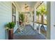 Inviting porch with rocking chairs, stylish rug, and views of tropical foliage at 3894 Sawyers Island Dr, Mount Pleasant, SC 29466