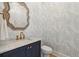 Elegant powder room with palm wallpaper, marble countertop, stylish mirror, and navy blue vanity at 3894 Sawyers Island Dr, Mount Pleasant, SC 29466