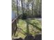 Fenced backyard featuring green grass, surrounding mature trees, and an open space at 399 Stefan Dr, Charleston, SC 29412