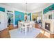 Bright dining room boasts a modern chandelier, fireplace, and ample natural light at 4 Kenilworth Ave, Charleston, SC 29403