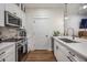 Well-lit kitchen with white cabinetry, stainless steel appliances, a stylish backsplash, and wood-look flooring at 400 Bucksley Ln # 103, Charleston, SC 29492