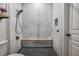Modern walk-in shower with gray hexagon tile, white marble and a wooden bench at 400 Bucksley Ln # 103, Charleston, SC 29492